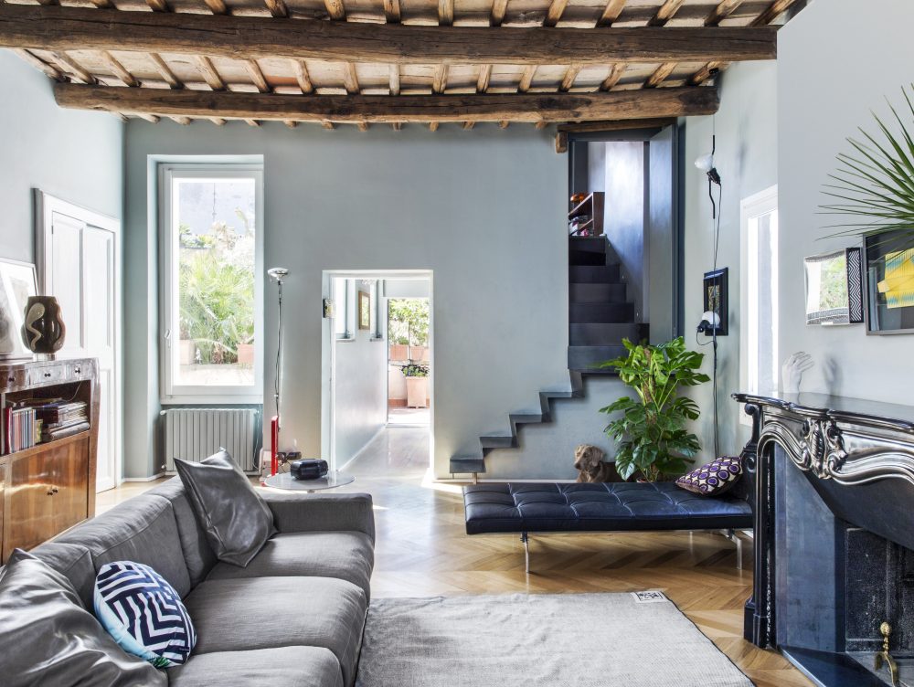 Travi a vista, mobili in radica e design contemporaneo in un appartamento sui tetti di Roma