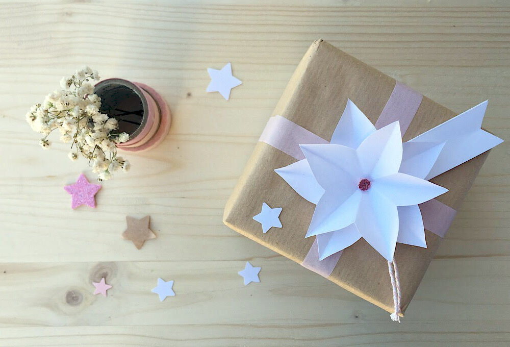 Decora i pacchetti regalo con una stella di Natale origami
